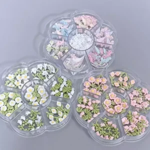 Close-up of soft-toned resin nail flowers and 3D butterflies in compartment trays