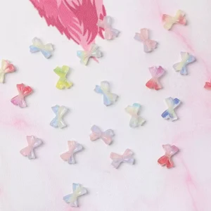 Close-up of pastel bow nail charms in soft rainbow tones