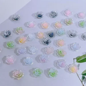 Iridescent rose nail charms arranged in gradient colors on card