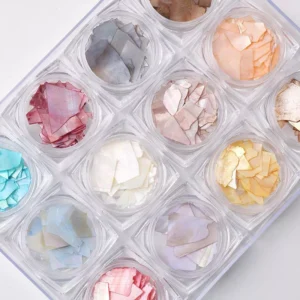 Zoomed-in shot of pastel shell nail art flakes stored in clear round boxes
