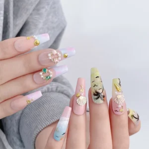 Realistic nail display using pastel shell nail decorations and beach-themed embellishments