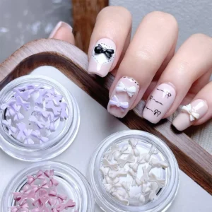 Nail design featuring pastel Pearl Bow Nail Charms and six open jars of charms