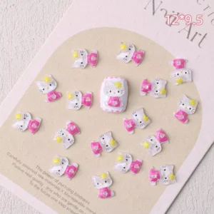 Kawaii white cat nail charms wearing pink dresses and yellow stars