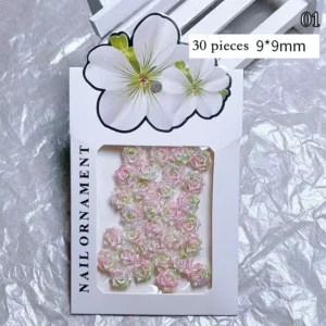 Pack of 30 pink and green iridescent rose nail charms in retail packaging