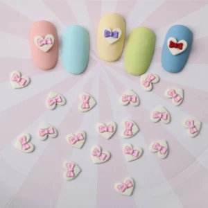 Pink bow heart resin charms scattered under pastel press-on nails
