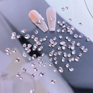 Assorted pink rhinestones including stars and ovals on reflective black surface