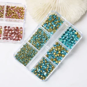 Crystal rhinestones in pink and turquoise hues, organized by size for easy access in a clear container.