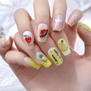 Manicure featuring various fruit crystal nail charms and hand-lettering
