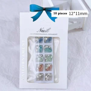 Elegant rhinestone nail decorations in various colors, packaged in a professional box