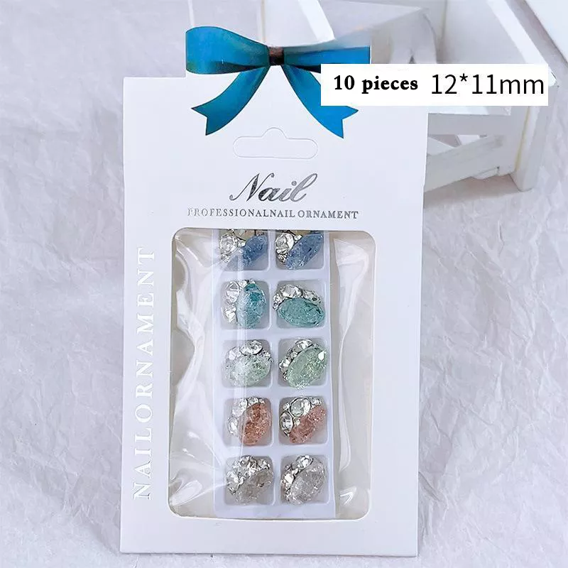 Elegant rhinestone nail decorations in various colors, packaged in a professional box