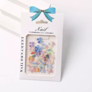 Multicolor rainbow bow nail charms in packaging with iridescent finish