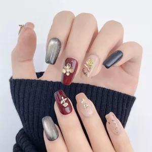 Natural lighting showing complete nail set with gold floral charms • Title: Real wear view