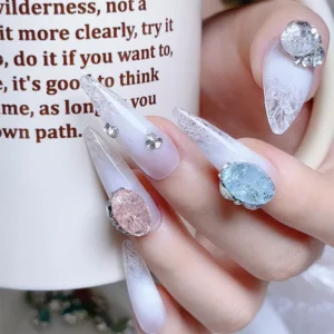 Rhinestone-adorned stiletto nails with a blend of pastel blue and white