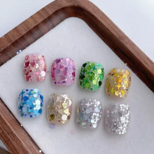 Set of nail tips showcasing Aurora holographic nail sequins in pink, green, yellow, blue, silver, and neutral tones