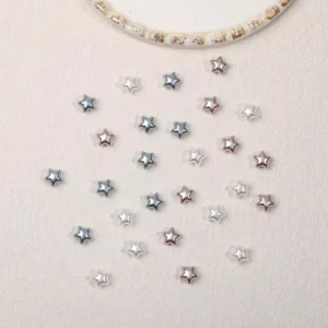 Silver, white, and rose gold star nail decorations arranged for display