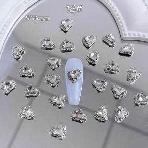 Heart-shaped silver rhinestone nail charm on light blue nail base