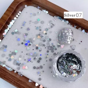 Silver iridescent nail glitter with reflective heart and star shapes on tray