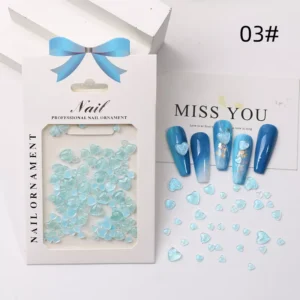 Blue resin heart nail charms in a boxed display with demo nails