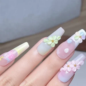 Close-up of soft pastel floral nails with gold bead centers