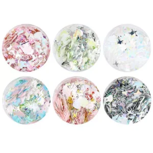 Close-up of six glitter jars featuring stars, moons, and pastel shapes