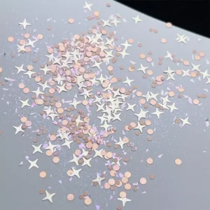 Rose gold and white star-shaped sparkle nail sequins scattered on surface