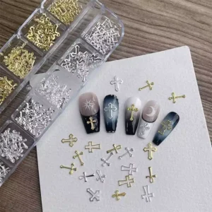 Flat lay of gold and silver cross nail charms and nails on paper