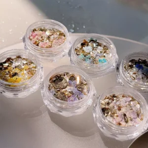 Pressed flower and gold foil nail glitter reflecting sunlight