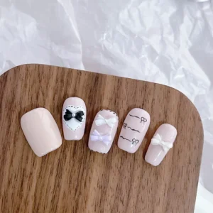 Nail art sample board with various Pearl Bow Nail Charms in elegant pastel tones