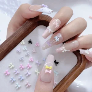 Close-up of pastel Sweet Resin Bow Nail Charms applied on long acrylic nails with matching display tray