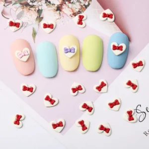 Mixed-color sweetheart bow nail charms in red, pink, and purple on pastel nails