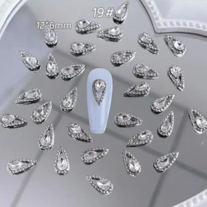 Long teardrop nail charm with silver halo on glossy pale base