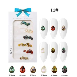 Teardrop-shaped resin nail charms in mixed finishes such as abalone, red, pearl, and tiger-eye tones