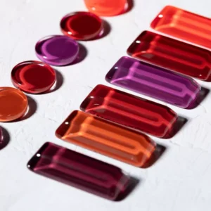 Macro of gel polish samples in red, orange, and purple hues