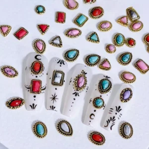 Assorted vintage turquoise nail charms on white base with gothic nail design