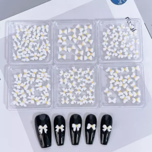 White bow nail decorations with yellow center for cute and clean nail looks