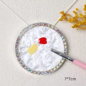 White round nail mixing tray with gel polish in red and yellow