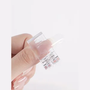 Transparent nail form clip securing a clear extension form on a thumb