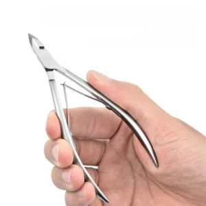 Silver stainless nail cuticle clipper held in hand for scale