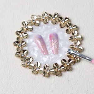 White shell-texture nail display with gold floral frame and crystals