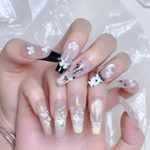 Clear mini bow nail charms on model hand with glitter nail art