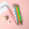 Five swirl handle nail art dotting tools in assorted colors on pink background