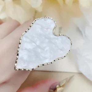 White pearlescent heart-shaped nail palette ring worn on finger